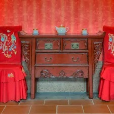 A room with two chairs and a table with a vase on it related to Unveiling the Elegance of Antique Chinese Sideboards