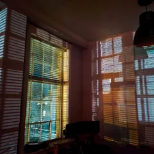 a room with two windows that have blinds on them related to Window Treatments 101: Mastering Curtains, Swags, and Valances