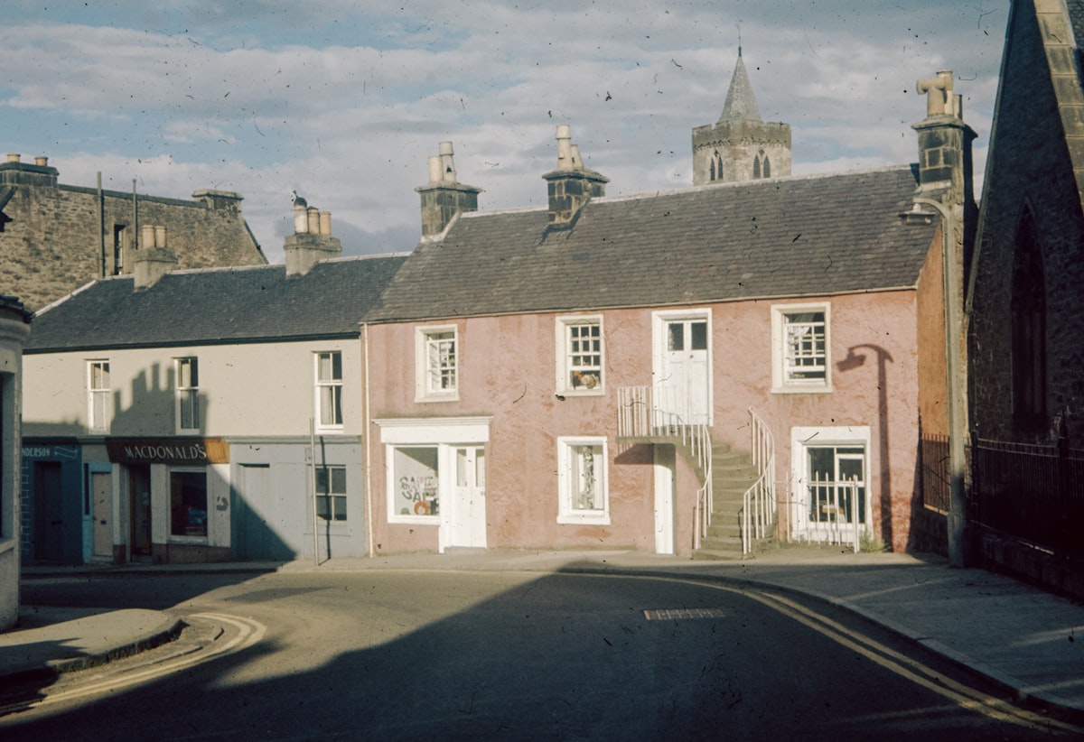 a row of houses on a street with a sky background related to Charming Stay at a Historic Bed & Breakfast
