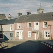 a row of houses on a street with a sky background related to Charming Stay at a Historic Bed & Breakfast