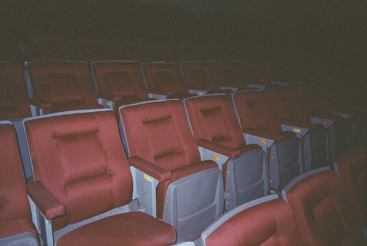 A row of red and gray seats in a stadium related to Revolutionizing Comfort: The Rise of Movie Theatres with Beds