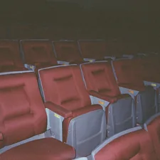 A row of red and gray seats in a stadium related to Revolutionizing Comfort: The Rise of Movie Theatres with Beds
