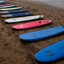a row of surfboards sitting on top of a sandy beach related to Sideboards on Sale: Unbeatable Deals for Your Home Decor