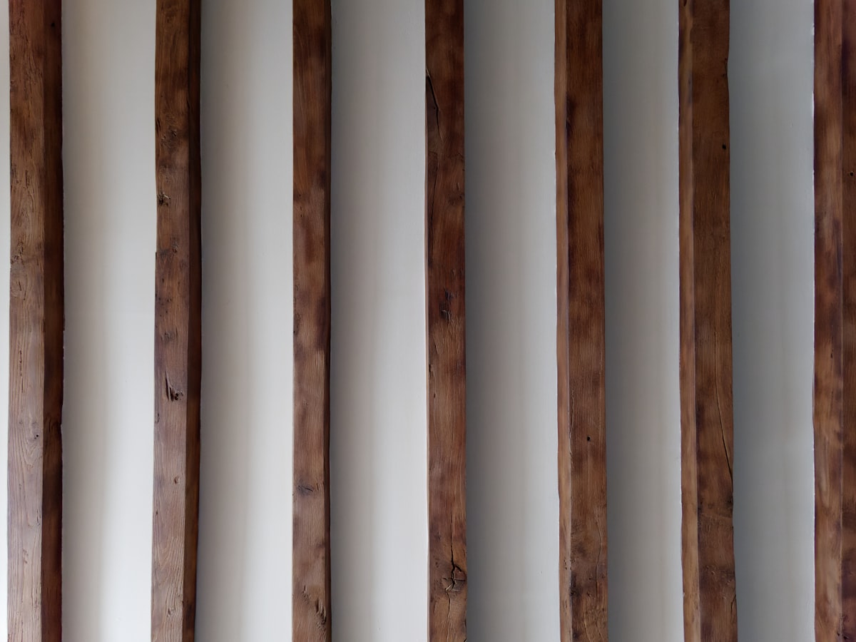 a row of wooden poles against a white wall related to Elevate Your Sleep Experience with Wooden Bed Slats: The Ultimate Guide
