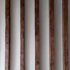 a row of wooden poles against a white wall related to Elevate Your Sleep Experience with Wooden Bed Slats: The Ultimate Guide