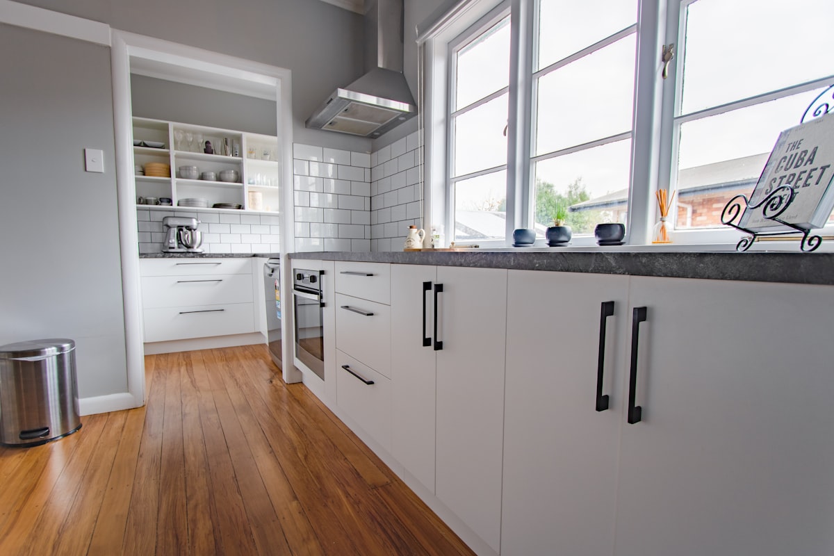 A simple white kitchen with black handles in an old train house. Kitchen designed in New Zealand by Kitchens Made Ezi related to Revolutionize Your Kitchen with the Perfect Sideboard