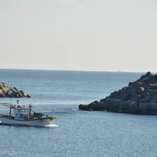 a small boat in a large body of water related to Coastal Charm: Seashore and Nautical Window Valances