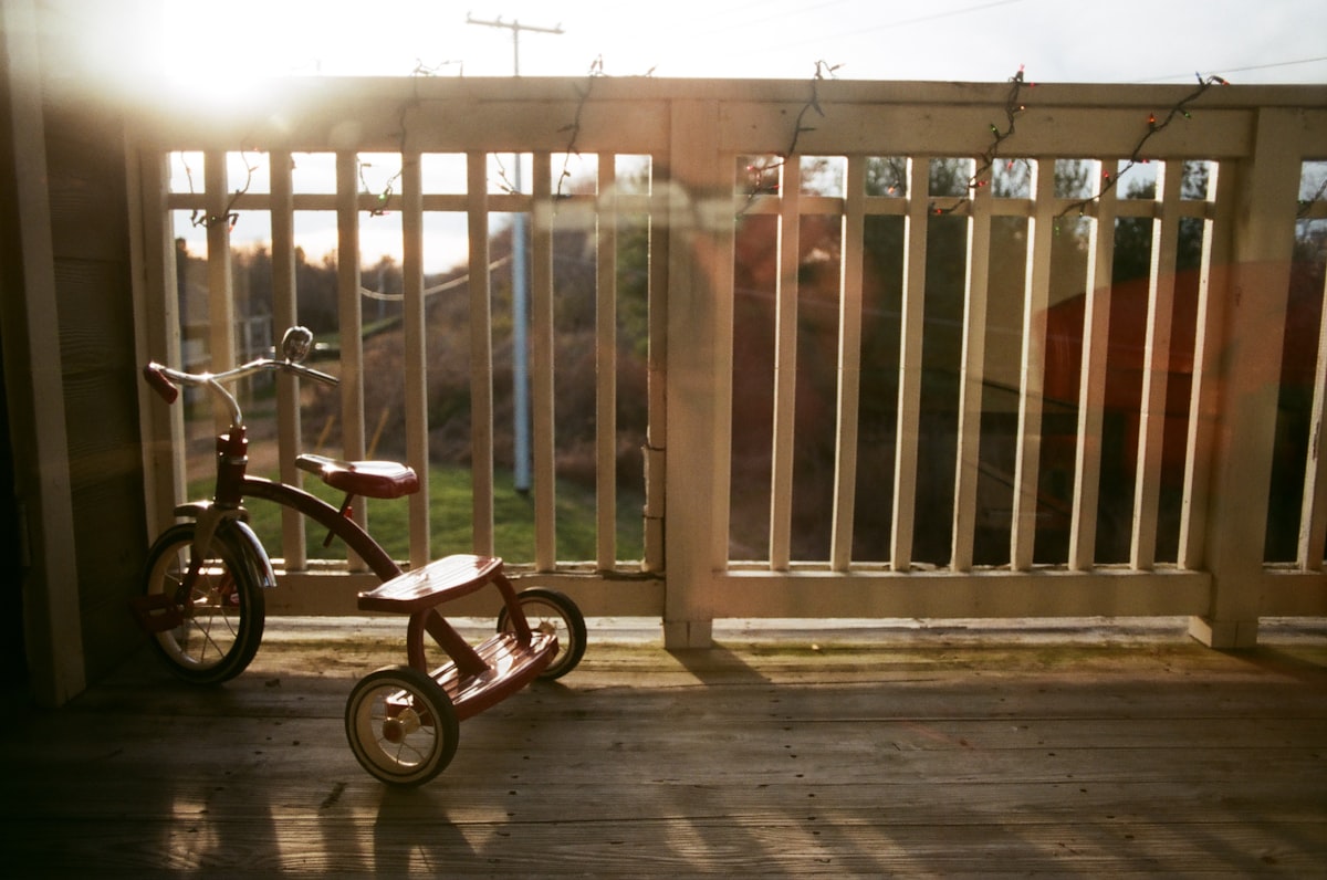 a small wooden tricycle sitting on a porch related to Transform Your Outdoor Space with Bed Bath and Beyond Patio Furniture