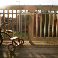 a small wooden tricycle sitting on a porch related to Transform Your Outdoor Space with Bed Bath and Beyond Patio Furniture