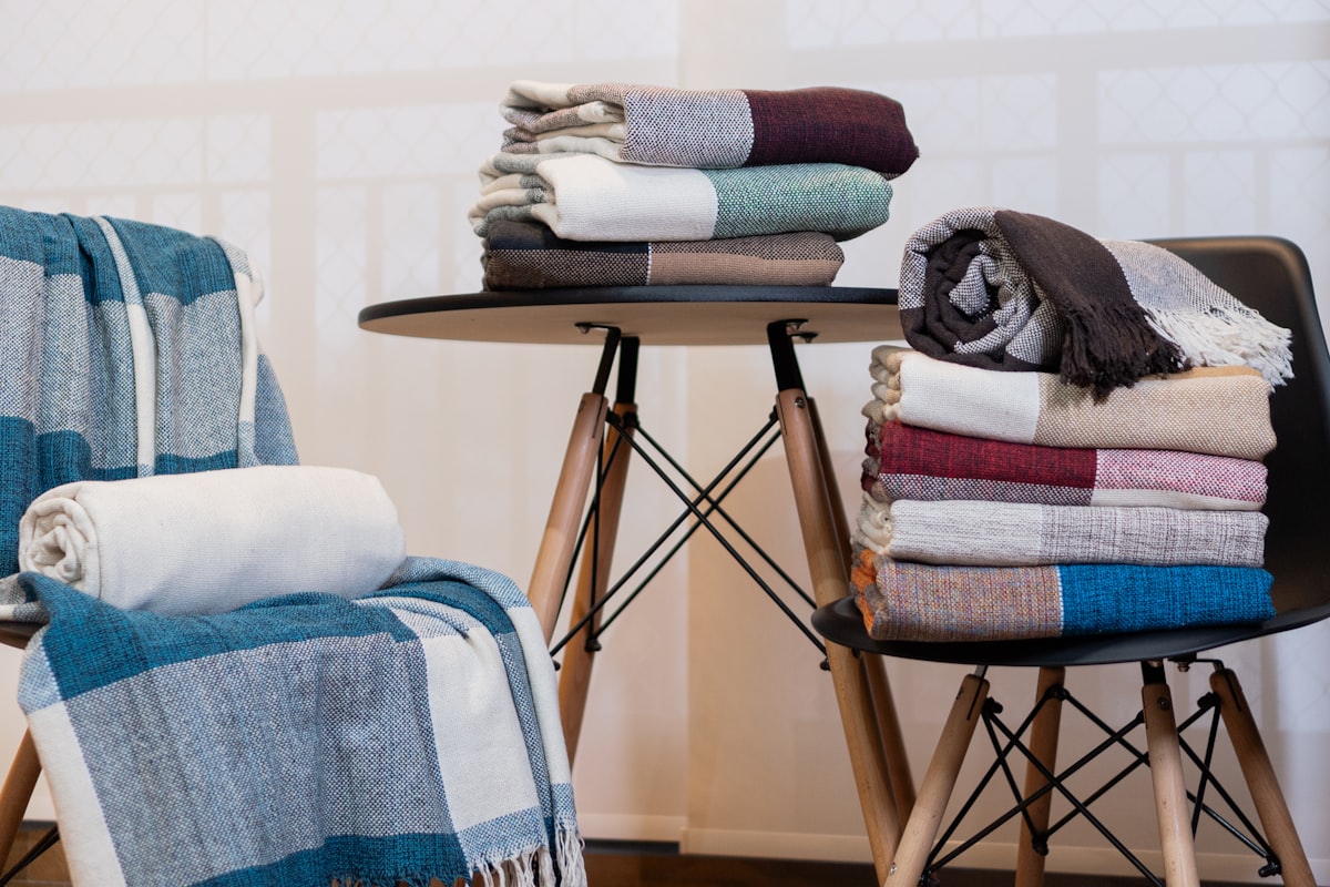 A stack of folded towels sitting on top of a chair related to Exploring Cozy Options for Blankets at Bed Bath and Beyond