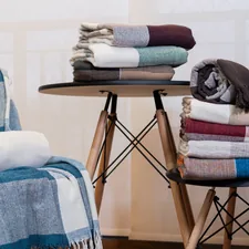 A stack of folded towels sitting on top of a chair related to Exploring Cozy Options for Blankets at Bed Bath and Beyond
