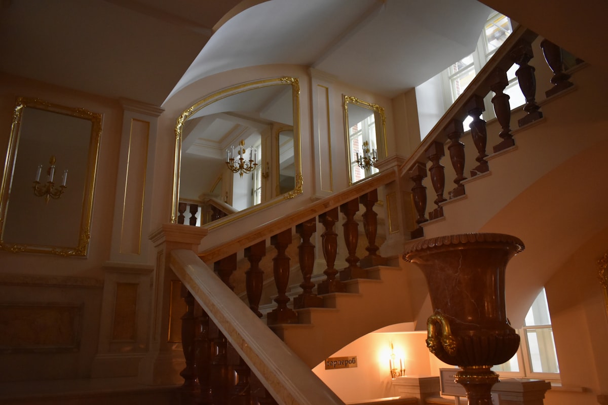a staircase with a mirror on the wall related to Elegant Entryways: A Comprehensive Guide on How to Decorate Your Foyer