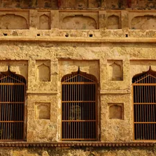 a stone building with four windows and bars related to Traditional Window Valances