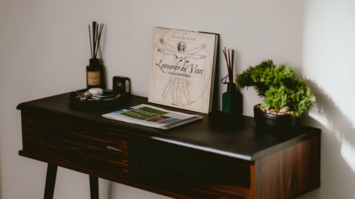 A table features books, plants, and scent diffusers. related to Elevate Your Entryway: Stylish Narrow Entryway Tables for Compact Spaces
