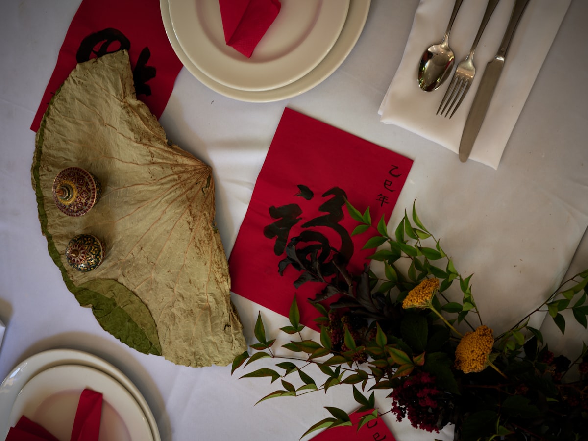 A table is set with red napkins and silverware related to Elegant Dining Experience: The Red Buffet Sideboard