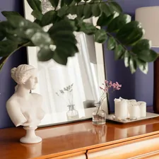 a table with a mirror and a vase with flowers on it related to Elevating Your Home Decor with Modern Valances Window Treatments