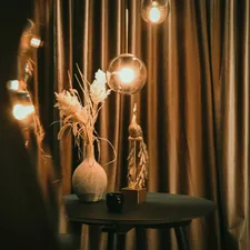 a table with a vase and some lights on it related to Complete Your Home Decor with Drapes and Matching Valances