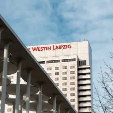A tall white building with a red sign on top of it related to Unravel the Bliss of Westin Heavenly Bed