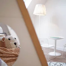 a teddy bear sitting on a bed in a room related to Beyond the Basics:  Transforming Kids' Bedrooms with Extraordinary Beds
