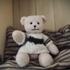 a teddy bear sitting on top of a bed related to How to Build the Perfect Bear Bed for Your Furry Friend