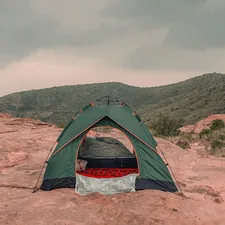 a tent pitched up on a rocky outcropping related to Sleep Under the Stars: Ultimate Guide to Tents for Beds