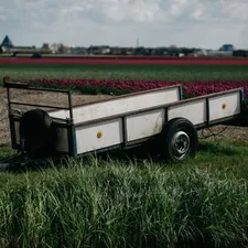 A trailer parked in a field next to a body of water related to The Ultimate Guide to Choosing the Right Pickup Bed Trailer