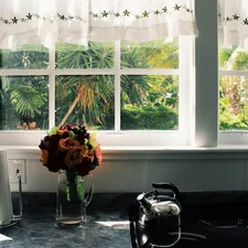 a vase of flowers on a table related to Kitchen Valance Curtains