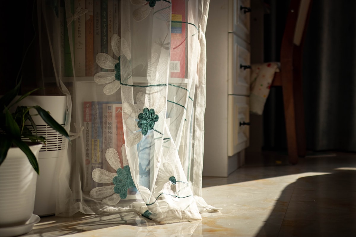 a vase with flowers related to Elevate Your Curtains: Sheer Valances with Beads