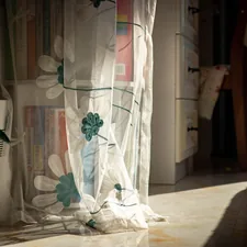 a vase with flowers related to Elevate Your Curtains: Sheer Valances with Beads