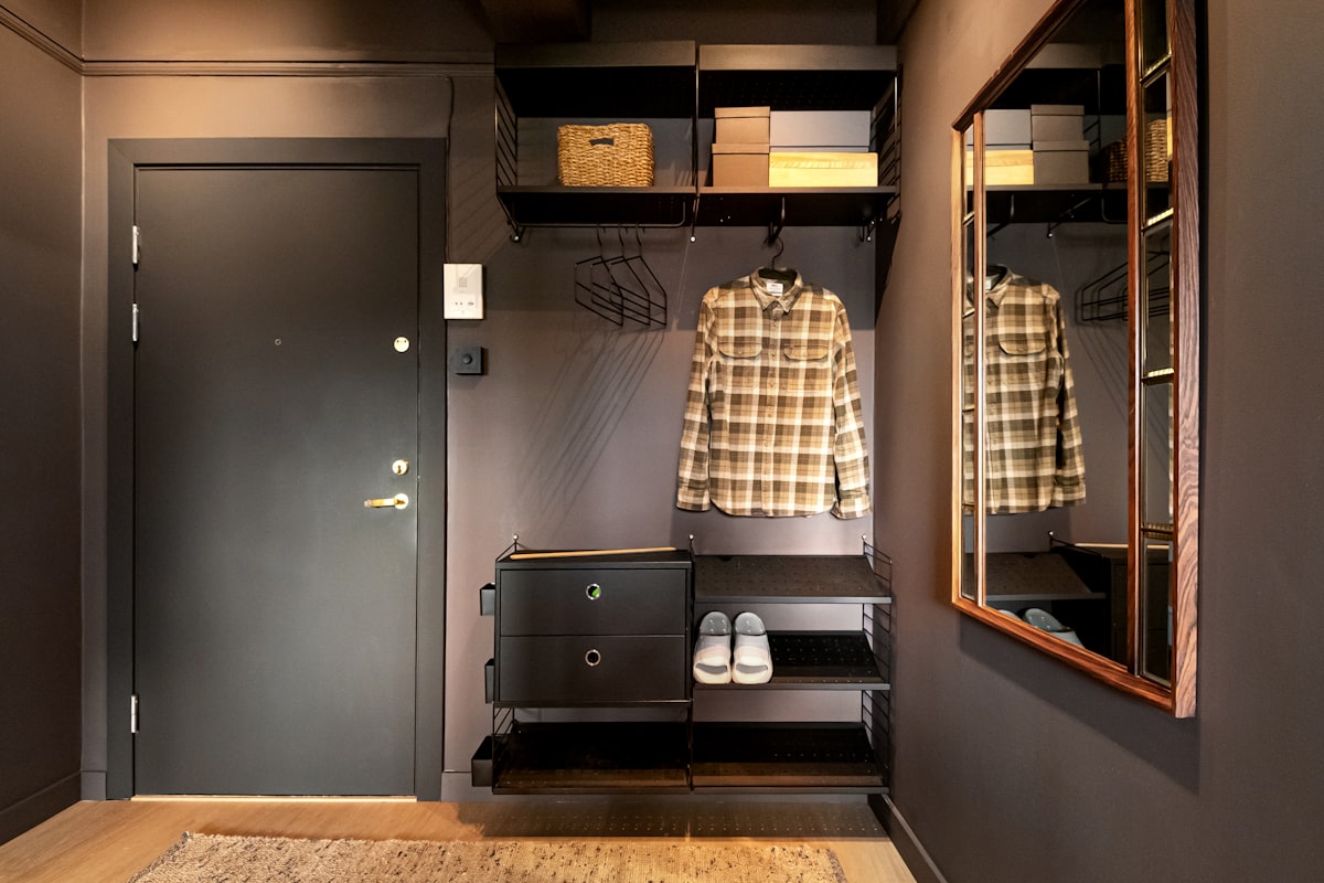 A walk in closet with a wooden floor related to Unlocking Potential:  Entryway Closet Design