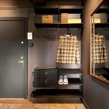 A walk in closet with a wooden floor related to Unlocking Potential:  Entryway Closet Design