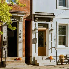 A white building with a brown door and windows related to Sleep in Historic Charm: Bed & Breakfasts of Pennsylvania