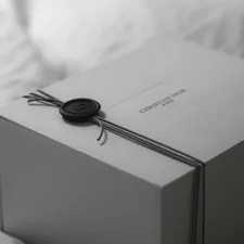 A white gift box tied with ribbon and wax seal. related to Exclusive Limited Edition Sleep Bed: The Ultimate Comfort Experience