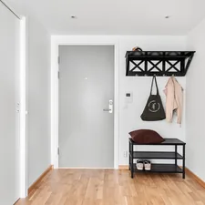 A white hallway with a bench and coat rack related to Metal Entryway Bench with Coat Rack: A Perfect Combo for Your Home's Entrance