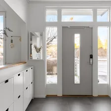 A white hallway with a gray door and white cabinets related to Maximizing Entryway Style with Elegance