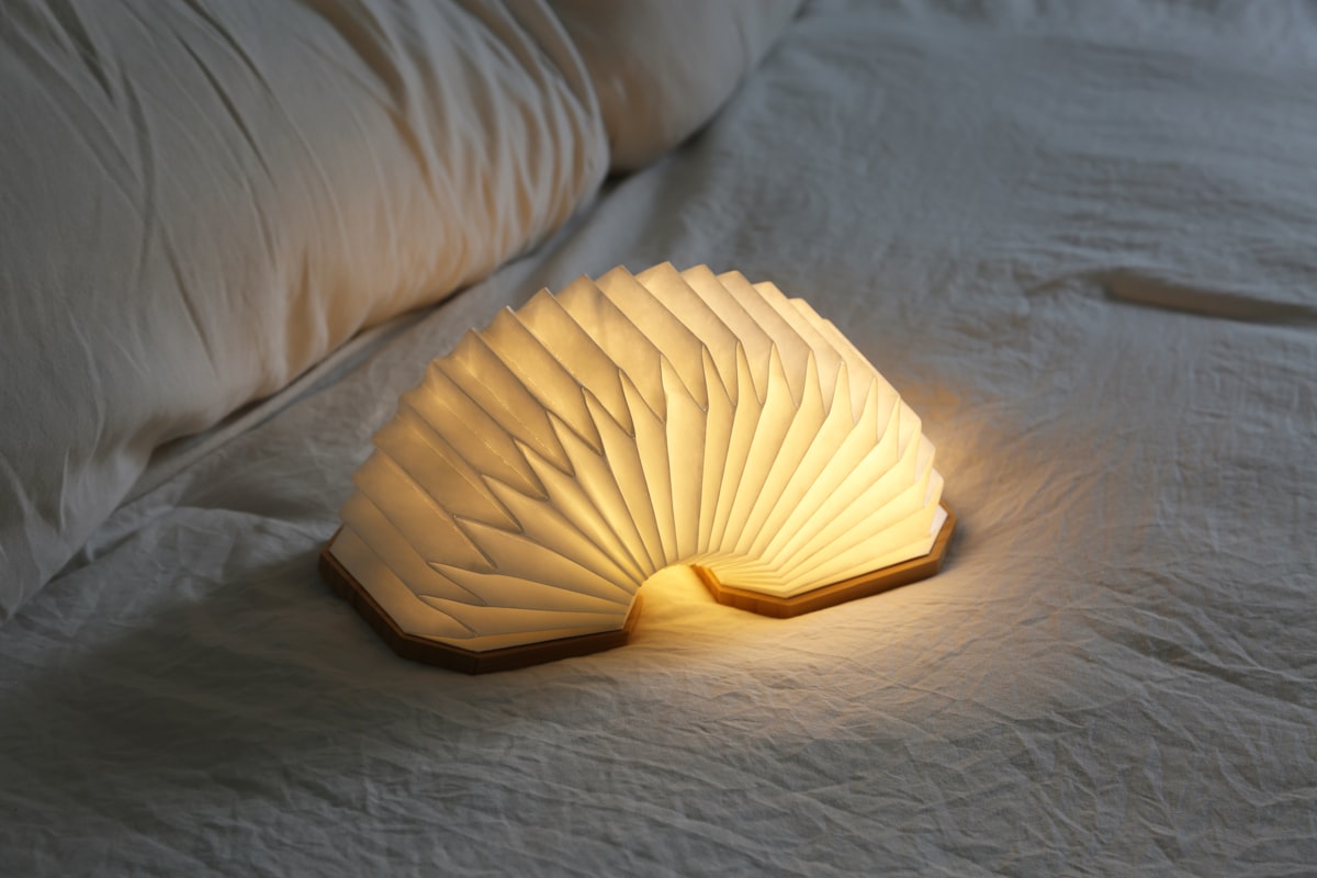 a white lamp sitting on top of a bed related to Exploring the Benefits of Yellow Bed Sheets