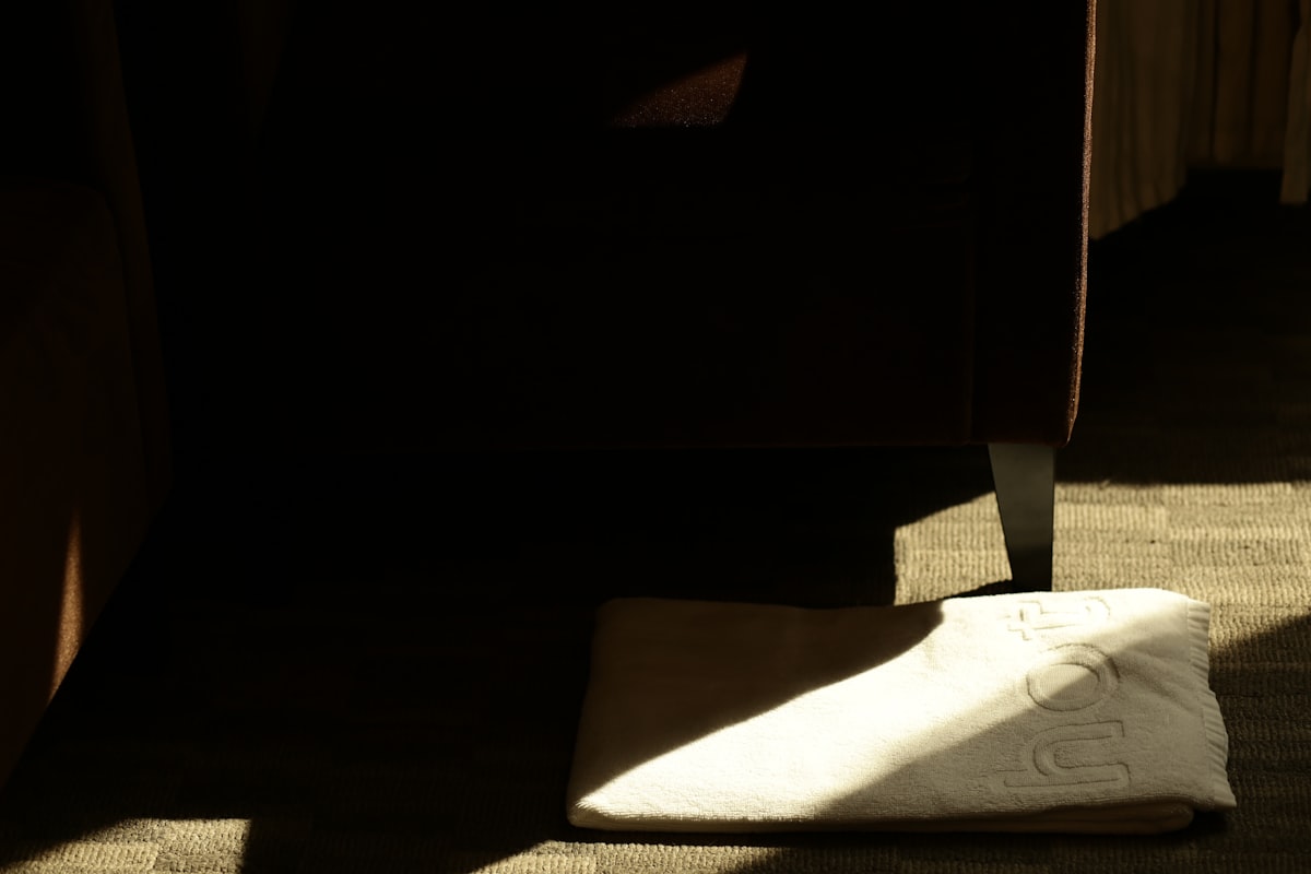 A white shoe rests on a textured surface in shadow. related to Elevate Your Sleeping Experience with Extra Wide Bed Risers