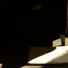 A white shoe rests on a textured surface in shadow. related to Elevate Your Sleeping Experience with Extra Wide Bed Risers