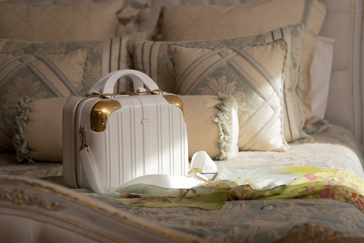 a white suitcase sitting on top of a bed related to Queen-Sized Comfort: The Ultimate Guide to Bed in a Bag Sets
