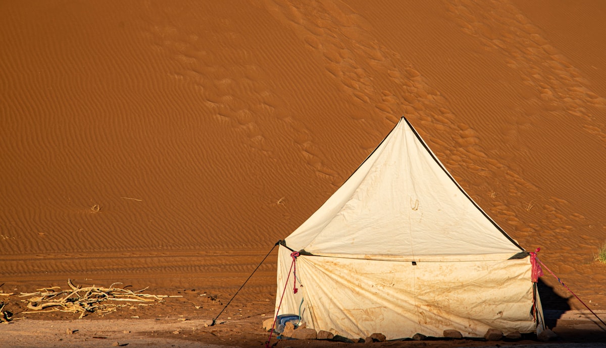 A white tent stands in a vast desert landscape related to The Ultimate Guide to Choosing the Right Bed Bug Tent
