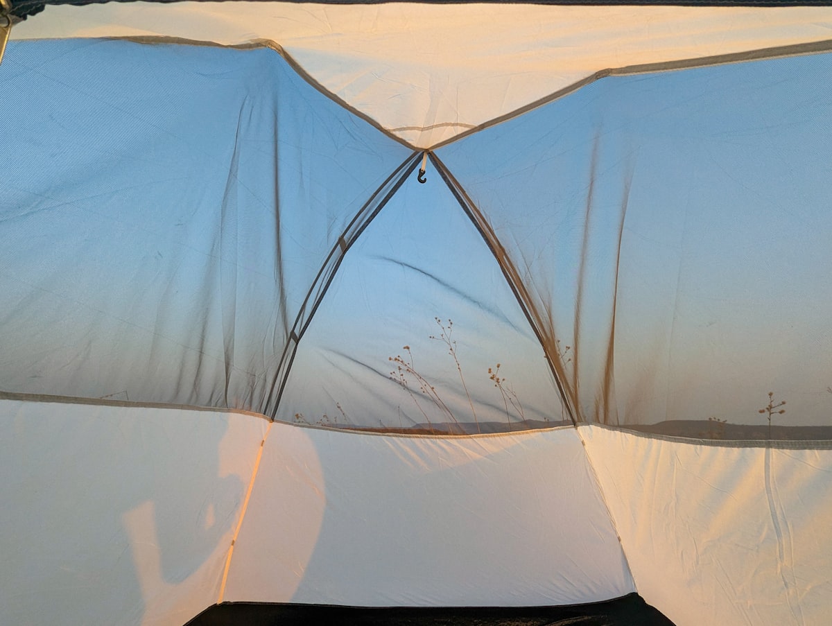 A white tent with a black bag on top of it related to Top Bed Tents for Twin Beds: Cozy Solutions for Kids and Adults