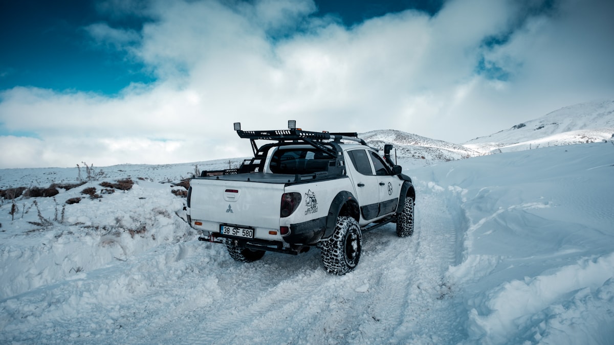 a white truck driving through a snow covered field related to Find the Best Truck Bed Covers Near Me: Top Options and Reviews