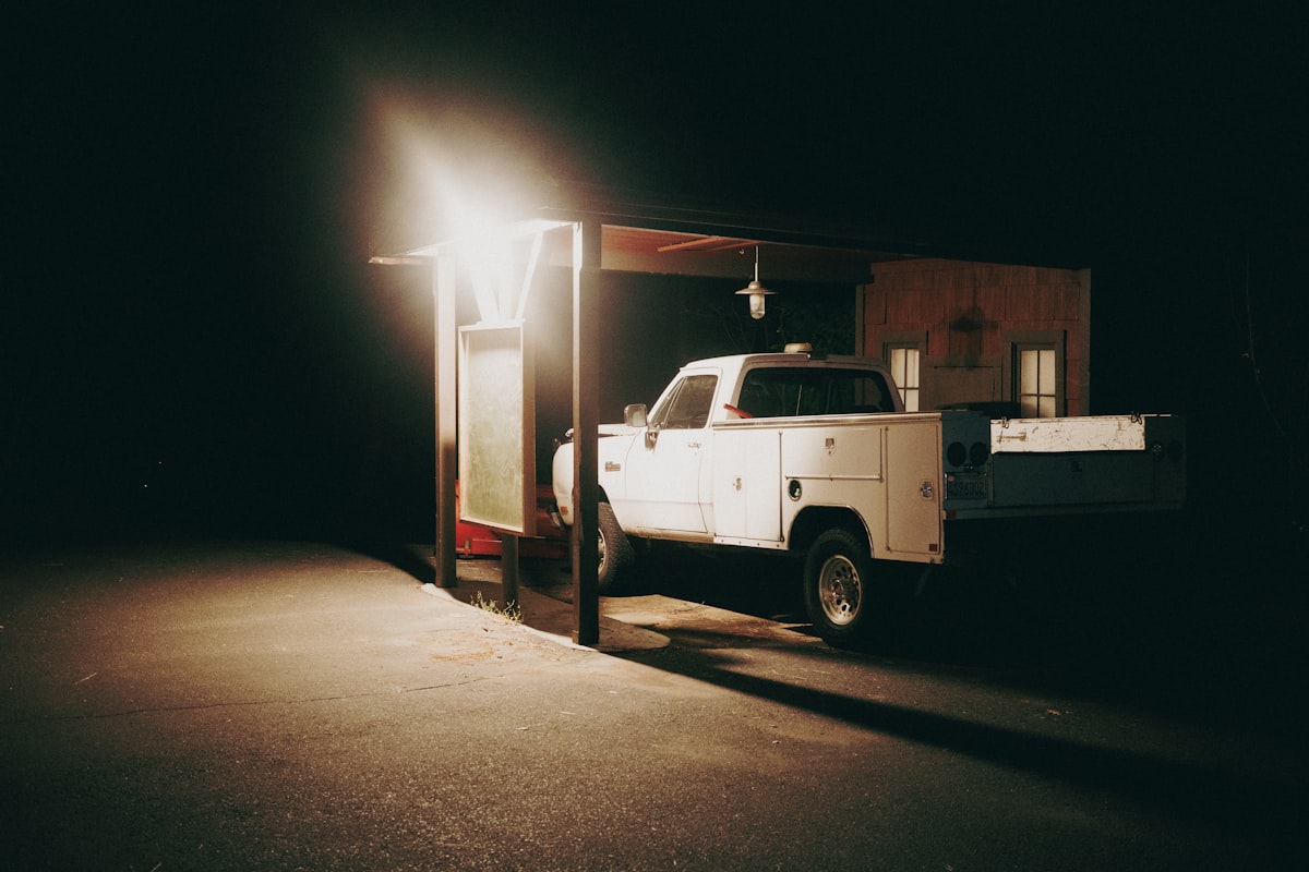 A white truck parked in a parking lot at night related to Transform Your Truck into a Cozy Home: The Ultimate Guide to Truck Bed Trailer Campers