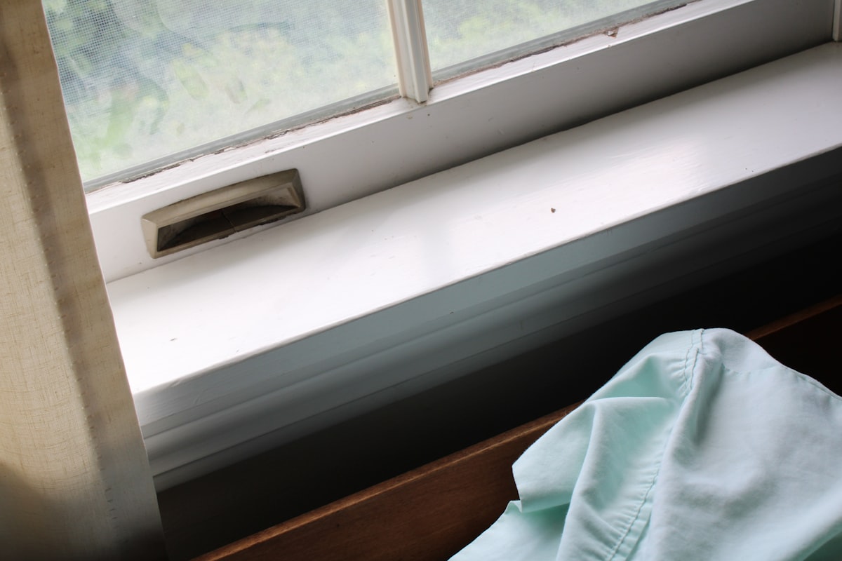 a window sill with a blue shirt on it related to DIY Window Valance: A Step-by-Step Guide