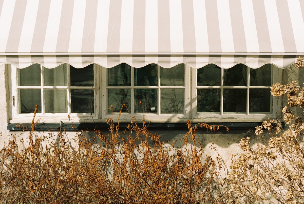 a window with a striped awning over it related to White Window Valance