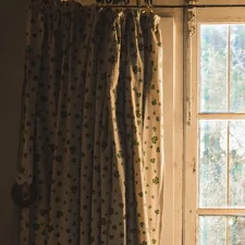 a window with curtains and a cat sitting on the window sill related to Elevate Your Windows with Curtains, Valances, and Swags