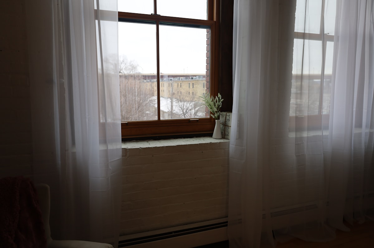 a window with sheer curtains and a potted plant related to Elegant Window Treatments: Box Pleat Valance