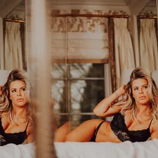 a woman in a black lingerie sitting on a bed related to Measuring the Majesty: Dimensions of a Queen Size Bed