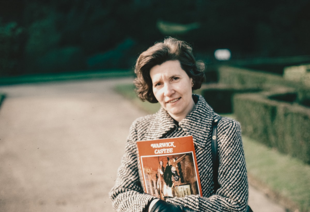 a woman is holding a book in her hands related to Martha Stewart Coverlet: A Comprehensive Guide