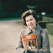 a woman is holding a book in her hands related to Martha Stewart Coverlet: A Comprehensive Guide